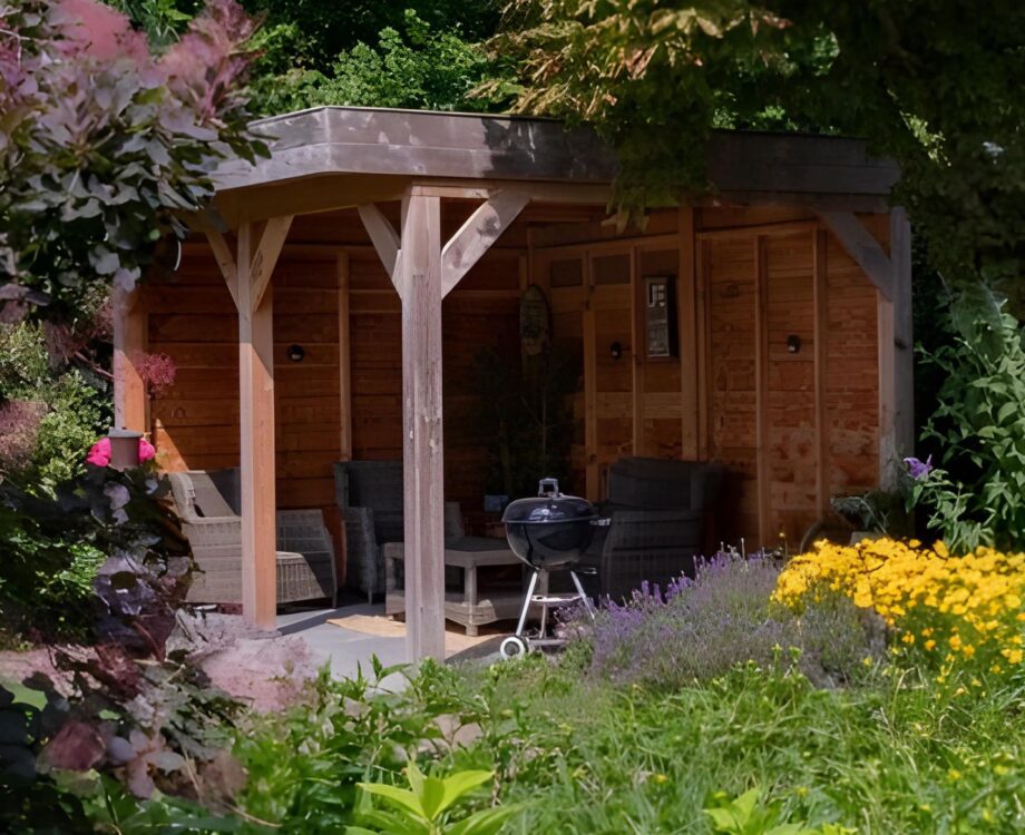 Tuinaanleg van een bostuin met tuinoverkapping in Huissen. Volle borders met kleurrijke beplanting.