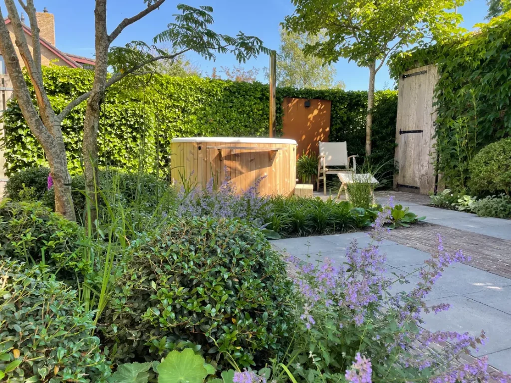 Jacuzzi in achtertuin van een groene tuin in Altforst. Deze tuin in ontworpen door de tuinarchitecten van Uw Tuin Hoveniers en aangelegd door de hoveniers van Uw Tuin Hoveniers uit Malden.