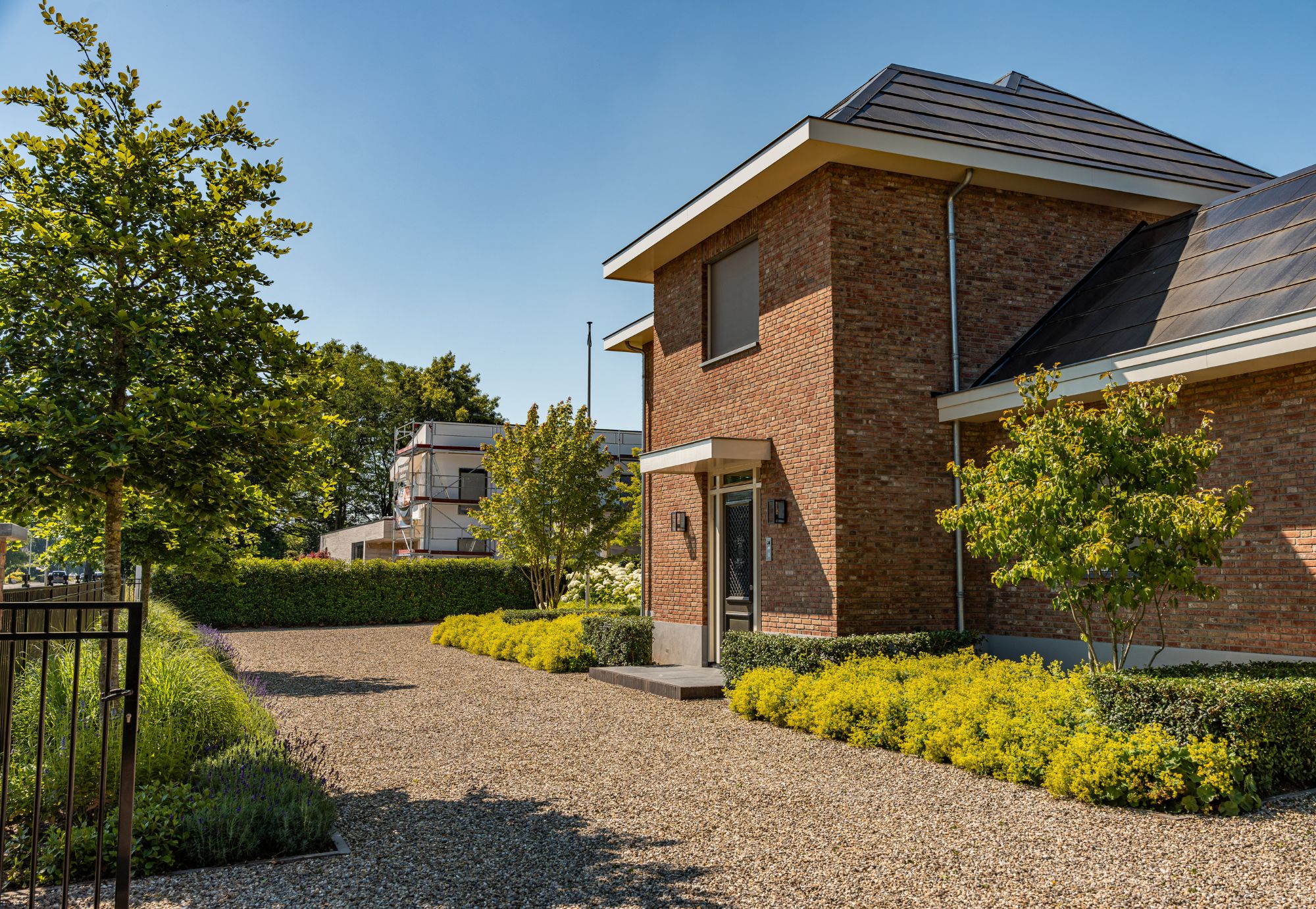 Vooraanzicht van een klassiek huis met een groene tuin in Malden. Tuinontwerp, tuinaanleg en tuinonderhoud door Uw Tuin Hoveniers uit Malden.