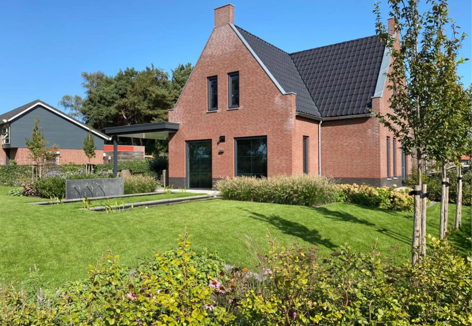 Moderne achtertuin met beplanting en vijver in Middelaar. Tuinaanleg door Uw Tuin Hoveniers uit Malden